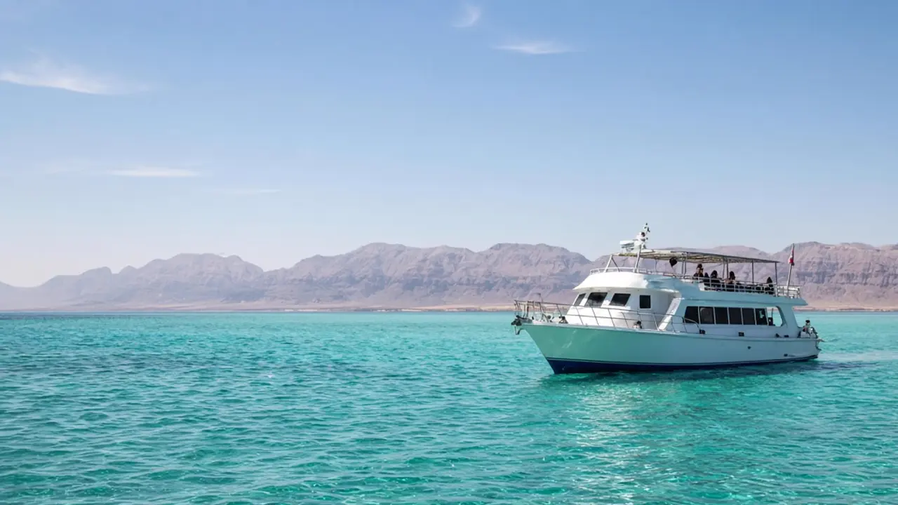 White dive boat on turquoise water with the Sinai mountains behind